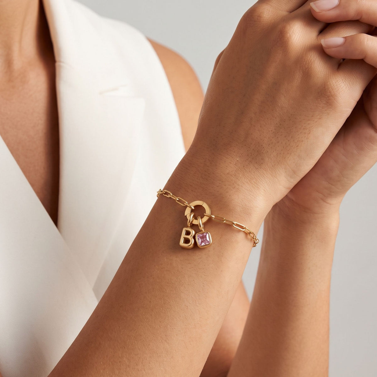 Orli initial and birthstone bracelet, Cali bangle and red tennis bracelet worn on a model