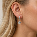 Sterling silver star huggie hoop worn on a blonde model
